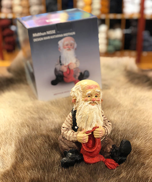 Midthun-nisse sittende med lue