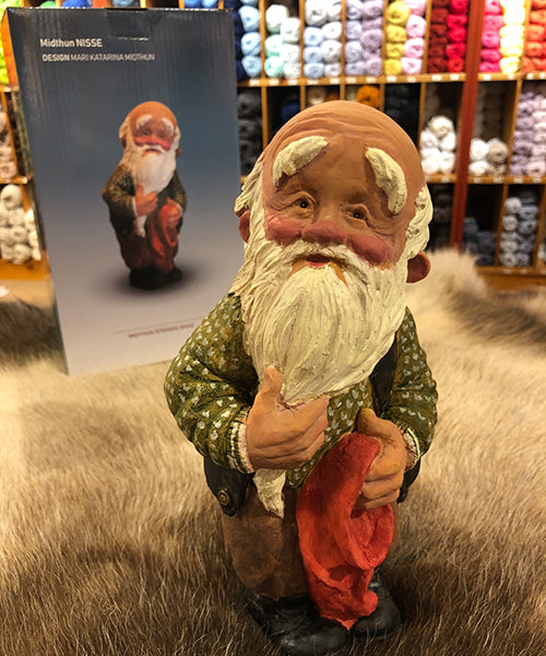 Midthun-nisse stående med lua i handa